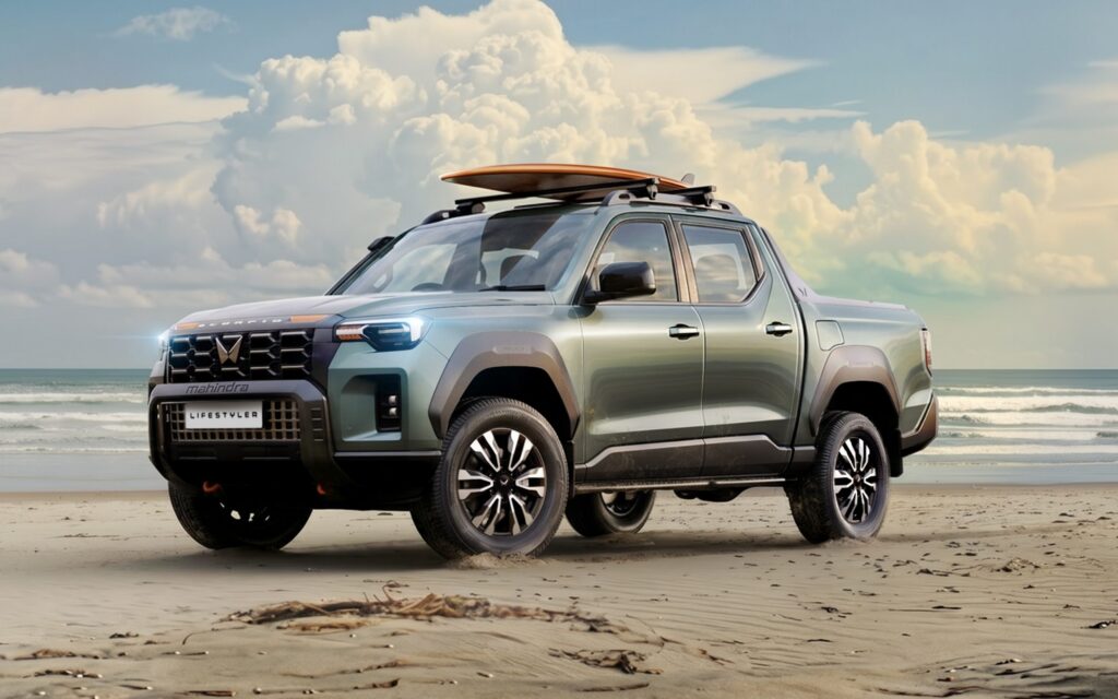 Silver pickup truck with an orange surfboard on the roof rack parked on a sandy beach, ocean and clouds in the background at sunset.